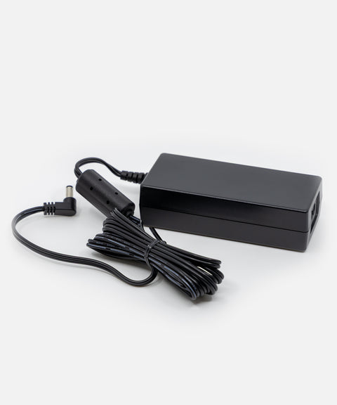 NEOZ 65W power supply with coiled DC cable – sleek black charger for N1 Charging Tray supporting up to six cordless lamps.