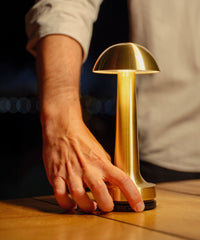 Hand attempting to lift a Cooee 1C Brass lamp secured by the NEOZ N1 Cordless Lamp Lock at 6HEAD Sydney